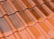 Czyszczenie dachówki ceramicznej - zbliżenie na&nbsp;dach podczas mycia z&nbsp;widocznym kontrastem między brudną a&nbsp;czystą powierzchnią.